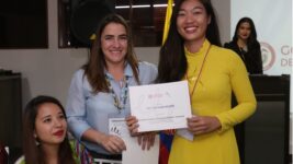 Fotografía de una estudiante recibiendo un certificado de culminación de estudios del Instituto Caro y Cuervo.