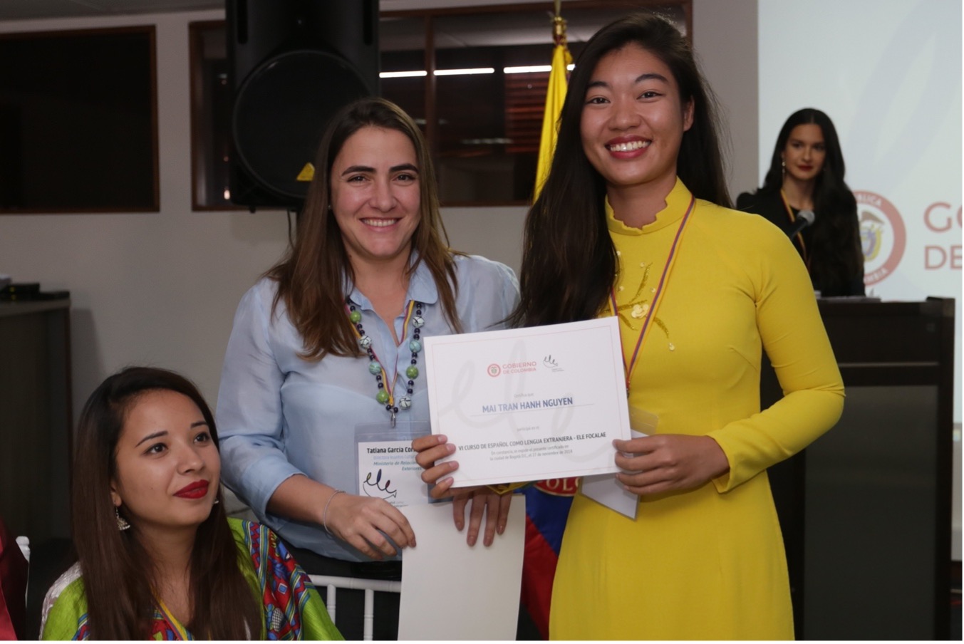 Fotografía de una estudiante recibiendo un certificado de culminación de estudios del Instituto Caro y Cuervo.